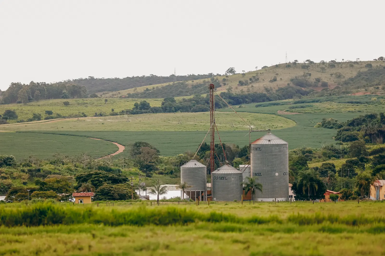 Os silos da Fazenda Palma junto à represa, com as lavouras e os morros verdes atrás